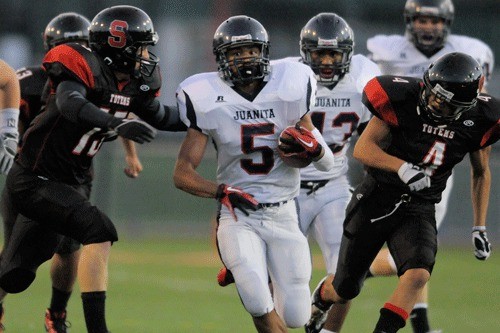 Juanita senior running back Andre Casino sprints past Sammamish defenders during the Rebels 58-0 blowout win over the Totems last Friday. The Rebels host Liberty this Friday night.