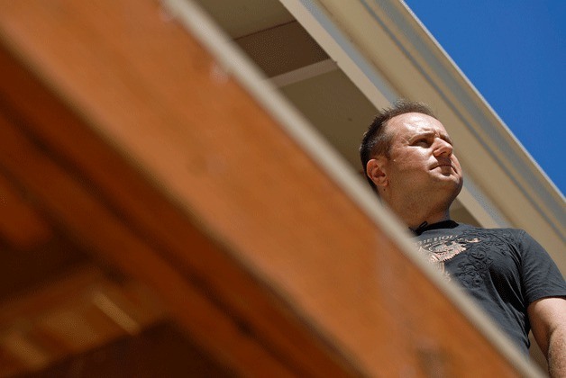 Leonid Milkin stands on his unfinished porch off the master bedroom during the rebuild of the his home in Kirkland