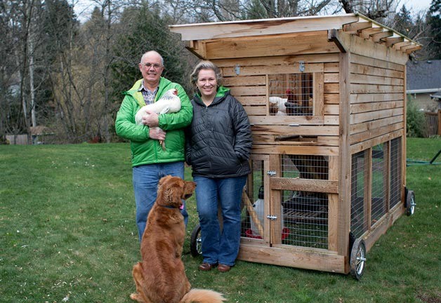 Kathy Weber and Bill Shain in front of their mobile chicken coop in the backyard of their Norkirk neighborhood home.