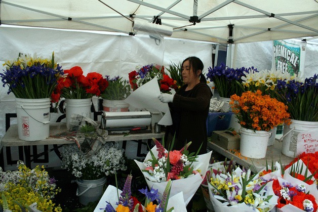 A vendor prepares flowers at the Kirkland Wednesday Market.