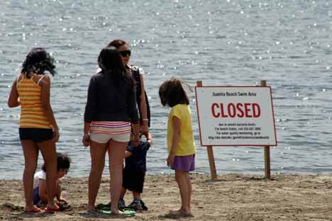 A group of girls play on the sand with the closure of the Juanita Beach swim area Friday afternoon.