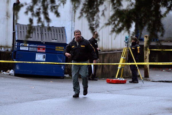 Washington State Patrol officers investigate an area behind the Juanita Albertson's grocery store for evidence in the suspicious death of a 19-year-old woman.