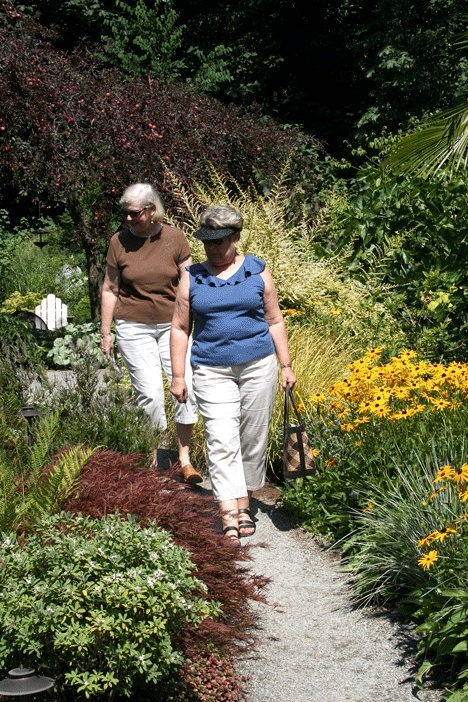 Judy Johnson (front) and friend Pat Howkinson walk through a certified wildlife sanctuary and botanical garden during the first annual Kirkland Gallery of Gardens Tour Sunday