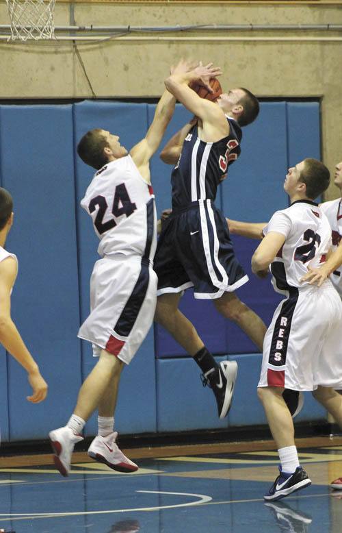 Juanita's Brett Hamre tries to block a shot by Nathan Hale during the Rebels first game of the 41st Annual Holiday High School boys basketball tournament at Bellevue College on Wednesday