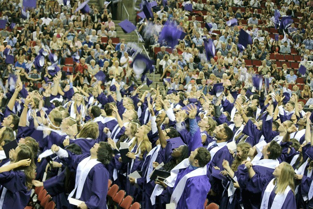 Lake Washington High School graduates throw their caps into the air during the 2015 commencement ceremony held at Key Arena in Seattle.