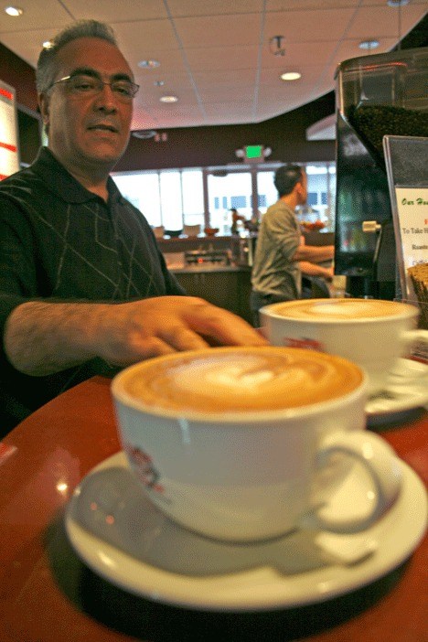 Zemarai Anjaz serves up a cup of coffee at St. James Espresso in Kirkland. His 19-year-old son