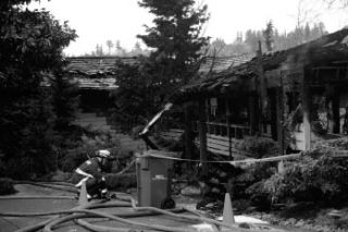 Kirkland Firefighter Todd Anderson adjusts a hose after several area fire departments put out a house fire the morning of Jan. 28 at Rose Point Lane