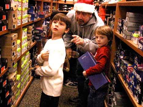 Local kids choose new shoes as a part of the annual Shoes from Santa event at the Totem Lake Fred Meyer. Hundreds of children and parents showed up at 6 a.m. on Saturday for the event. Retired local realtor Craig Shriner began the event as an alternative to a company holiday party eight years ago. Volunteers from Windermere Real Estate helped to raise the money to buy the shoes and also helped to organize the event.