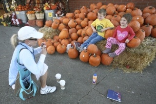 Emily and Luke Rex pose for a photo with pumpkins for their aunt