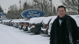 Ford of Kirkland managing owner Jim Walen stands in front of a row of Ford vehicles laden with snow during the recent snowstorm.