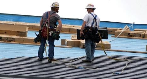 Construction workers pause for a conversation while installing the Kirkland Library's new roof. The expanded library is set to reopen in early 2010.