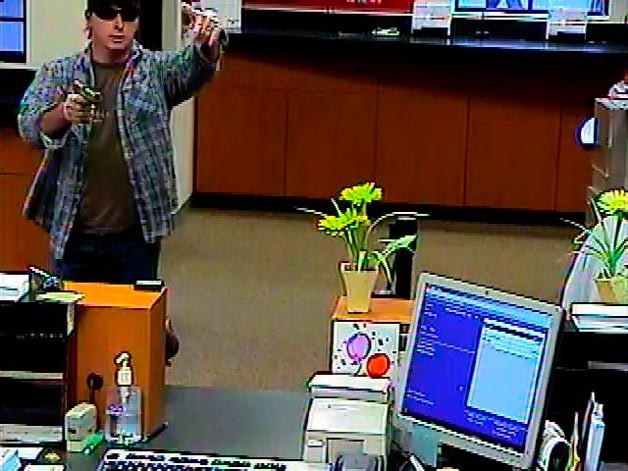 The FBI has arrested the 43-year-old Bothell man shown in this bank surveillance footage robbing the Juanita Village Bank of America at gunpoint on Aug. 5.