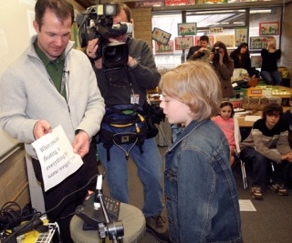 Carl Sandburg Elementary and Discovery Community School Principal Mark Blomquist holds up a question while a student reads it into a phone equipped with a mic so astronauts at the International Space Station can hear him on April 2.