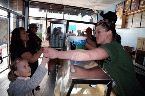 Sarah Conrad hands a free ice-cream cone to a young girl at the Kirkland Ben & Jerry's on Tuesday. The company was giving away a free ice-cream cones during it's annual appreciation event.