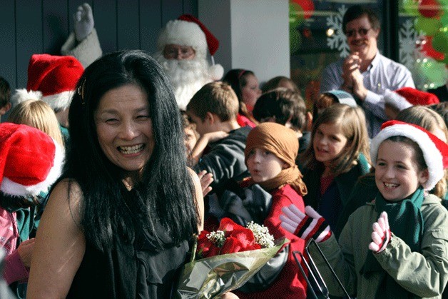 Thoreau Elementary School musical director Lesley Paige accepts a bouquet of roses from the manager of the Totem Lake Hallmark on Saturday