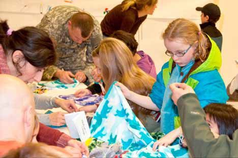 Students and parents make fleece hats to donate to Treehouse