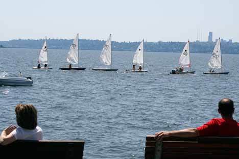 Kids climb aboard sail boats near Marina Park in Kirkland on Lake Washington during a hot summer day.