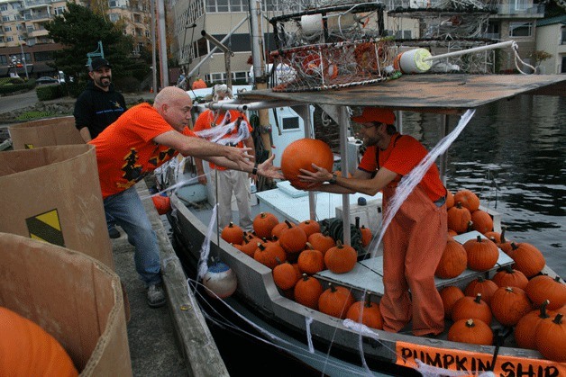 Volunteer George Strausser (left) throws a pumpkin to Otto Loggers