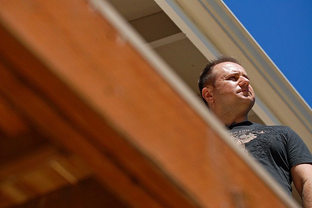 Leonid Milkin stands on his unfinished porch off the master bedroom during the rebuild of the his home in Kirkland