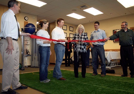 Kirkland Mayor Joan McBride cuts a ribbon during the grand opening ceremony at Lake Washington Physical Therapy on Oct. 15. Also pictured (from left) is Bill Vadino; executive director of the Kirkland Chamber; Lake Washington Therapy owners Sara Wobker and husband