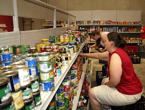 Hopelink employees Theresa Curry (front) and Erica Wright stock the shelves at the new Hopelink facility in Kirkland