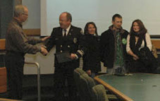 Kirkland Mayor Jim Lauinger (left) recognizes Kirkland Fire Department Capt. Larry Peabody for 30 years of service during a council meeting Dec. 16. Also pictured is Peabody’s family.