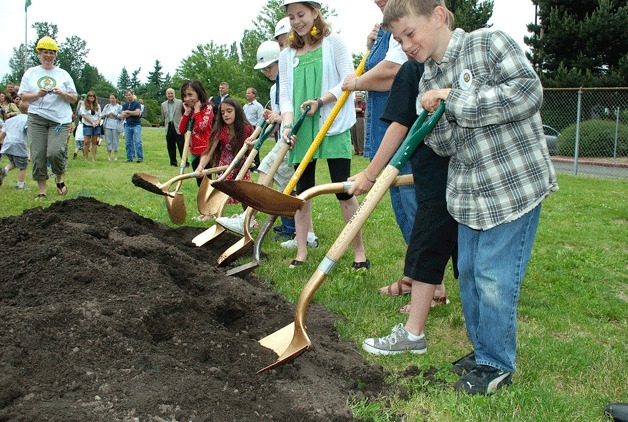 A.G. Bell Elementary students shovel the first pile of dirt during a ground-breaking ceremony at the school on June 22.
