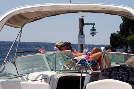 Brian Winn and Amanda Martinez enjoy a sunny Friday afternoon on a boat at the Kirkland Marina.