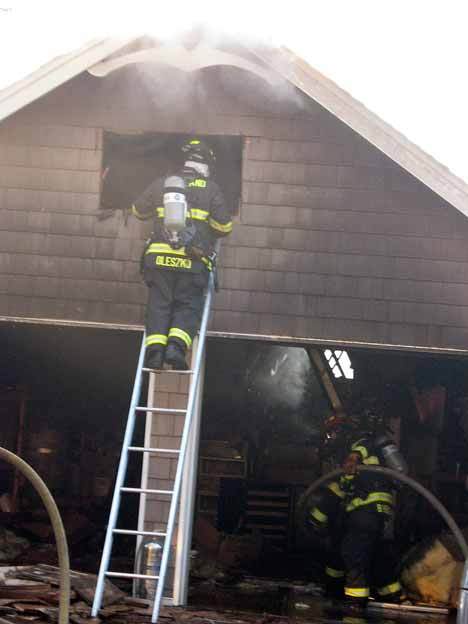 Kirkland firefighters work to put out remaining hot spots in a home in the 13000 block of Holmes Point Drive N.E. No one was hurt in the fire that destroyed the house