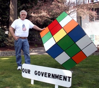 Bill Rosenthal stands next to a five-foot Rubik's Cube  cemented in the front yard of his Highlands home. He made the creation out of steel and plywood to symbolize the US government.
