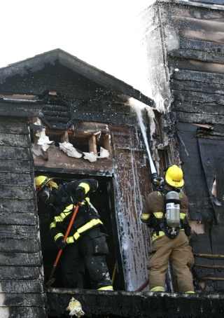 Firefighters spray foam and clear debris after an apartment fire at Juanita Brook Apartments on July 17. No injuries were reported