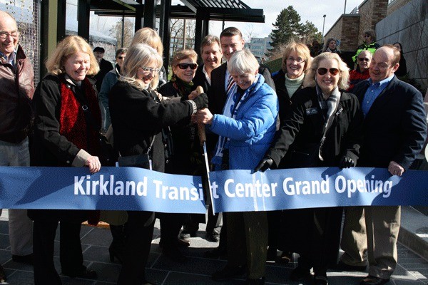 Kirkland Mayor Joan McBride and former mayor Mary-Alyce Burleigh cut the ribbon to officially open the Kirkland Transit Center. Behind the two are members of the Kirkland City Council and Sound Transit Board.