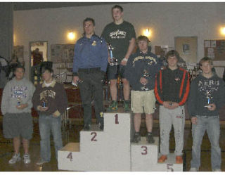 Grant Haschak stands on the podium after winning the 215-pound weight class at the Tri State Tournament in Couer d’Alene. To Haschak’s left: Konner Knudston (Tahoma)