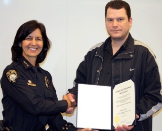 Bellevue Police Chief Linda Pillo congratulates Kirkland resident and ex-marine Kristopher Beal on his courageous act of bringing down a bank robber during a heist.