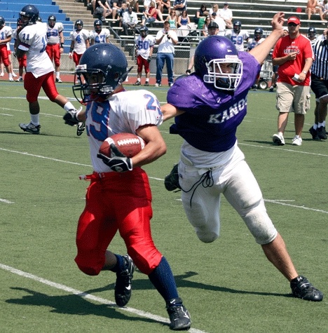 Juanita running back Sean Muong is grabbed from behind by a Lake Washington player during the two teams’ spring scrimmage.