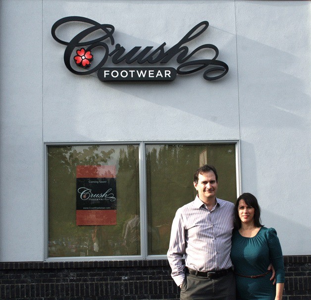 Neal Hughes and Rhonda Herbert stand in front of their shoe store