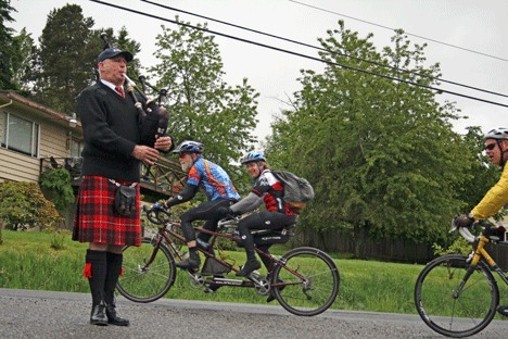 Neil Hubbard plays the bagpipes at the corner of 132nd Avenue Northeast and Northeast 145th Street at the top of Winery Hill during the annual 7 Hills bike event on Monday.