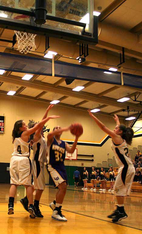 Kangs senior Kasey Coffey drives to the basket through three Viking defenders during her team’s 53-45 win.