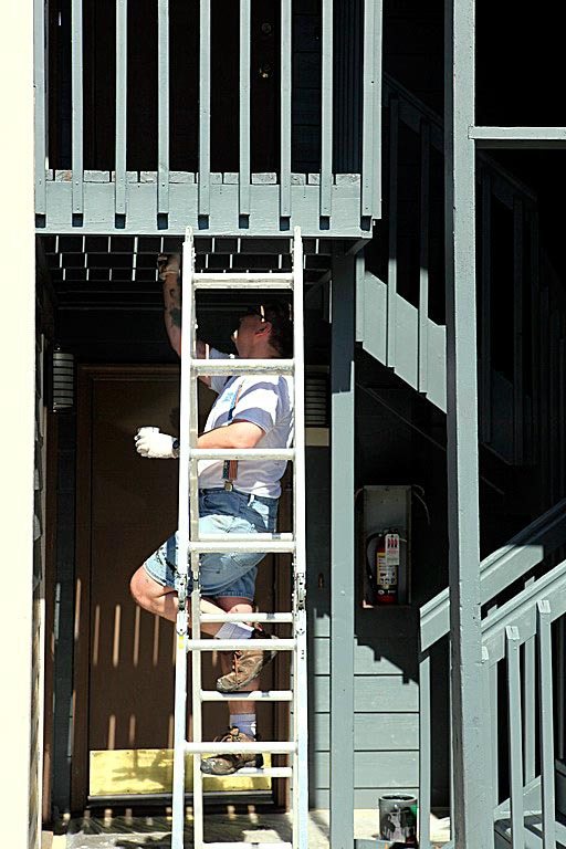 A Bellevue Breakfast Rotary Club volunteer paints the staircase of KITH's Salisbury Court housing on Aug. 27.