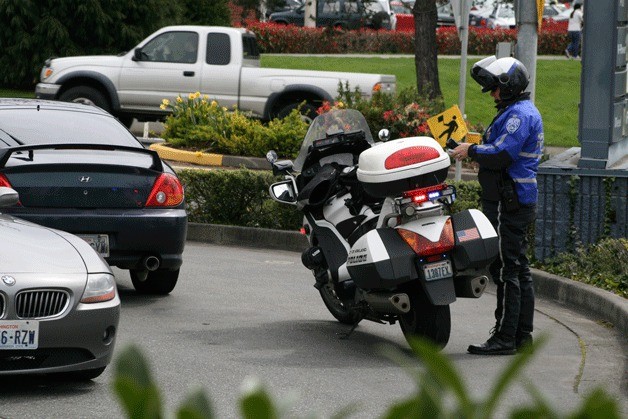 A Kirkland Police officer writes a traffic ticket in the parking lot of the Shell gas station on Central Way on April 5. The number of traffic stops in Kirkland has increased by 30 percent in the first three months of 2011