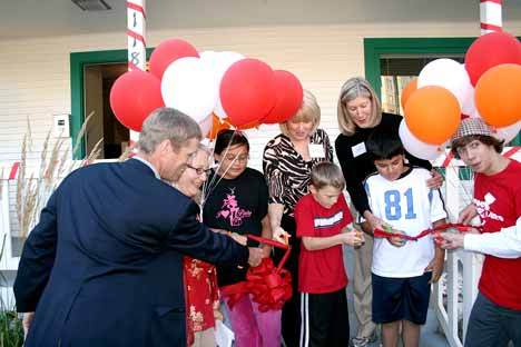 Local youth help officials cut the ribbon for the new Youth Eastside Services site at the historic Forbes house in Juanita Park. Pictured  is King County Council member Jane Hague (right)