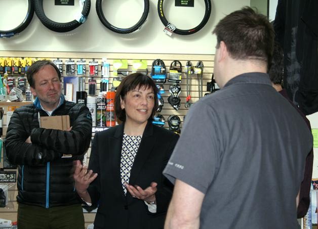 Congresswoman Suzan DelBene speaks with Kirkland Bicycle Shop co-owner Josh Harris about how the Internet tax loophole impacts business. REI government affairs director Marc Berejka listens during DelBene's Marketplace Fairness Act tour on Thursday.