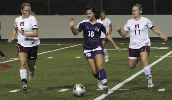 Lake Washington's Jessie Zogg (16) looks for a way around Mercer Island's Claire Jensen (5) and Tara Nielson (11) during the Kangs away win Tuesday night.