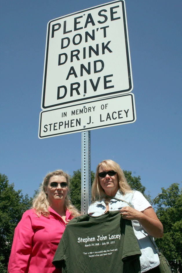 Kirkland residents Anna Rising and Deb McFarlane stand in front of a new sign that was installed on Tuesday near the site on N.E. 85th St. where their long-time friend