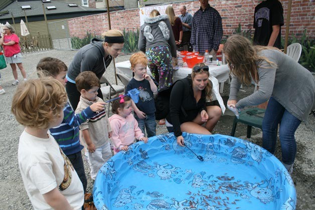 Community members round up goldfish to take home during the Goldfish Rodeo benefit in downtown Kirkland on Friday. The event raised college funds for the two young children of Steve Lacey