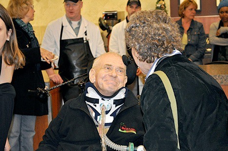 Robert 'Bob' Lehan is greeted by an old friend during an event to welcome him back to Red Apple Market in Bridle Trails