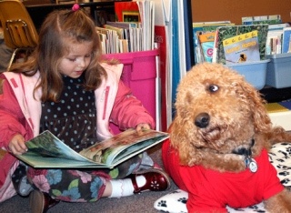 A pooch named Louie listens to Alexander Graham Bell kindergartner Emory Herbert read 'Carl's Afternoon in the Park.'