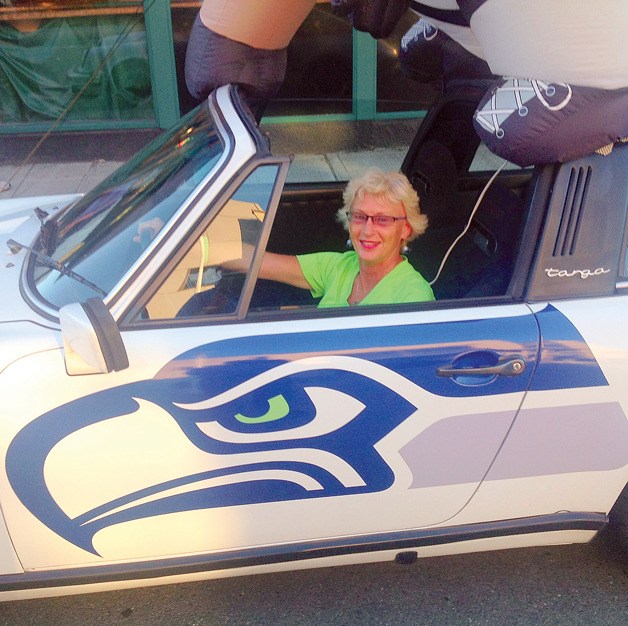Kirkland resident Terri Fletcher in a Seahawks-adorned collector vehicle at the Kirkland Classic Car Show. Fletcher organizes the annual event.