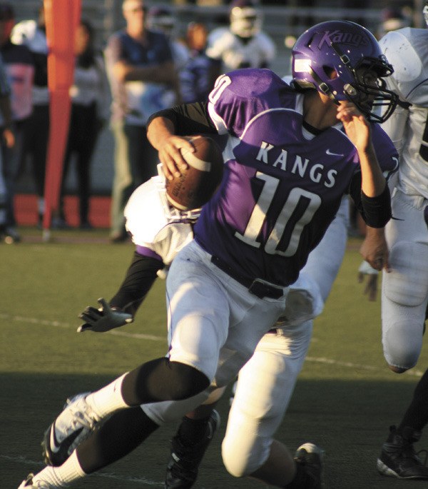 Lake Washington quarterback Shawn Gray (10) skirts around Garfield defenders while looking for an open route during Friday's season opener. The Kangs beat Garfield.