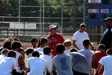 Juanita High School football head coach Shaun Tarantola adresses his team following a recent preseason workout.